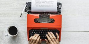 Aerial view of a man typing on a retro typewriter Aerial view of a man typing on a retro typewriter